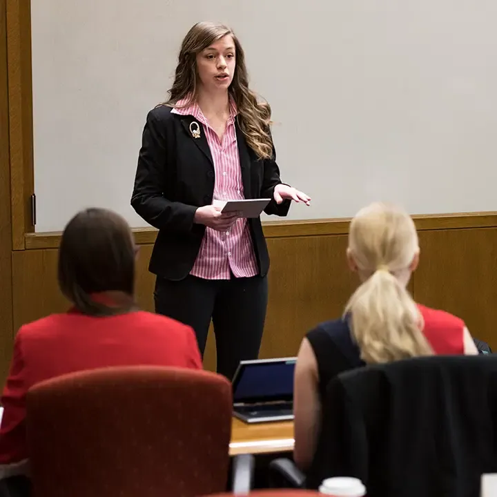 Woman speaking in front of room